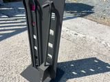 un objet métallique noir sur le trottoir, près de la rue
