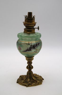 une lampe ancienne en laiton et en verre vert, ornée d'un oiseau