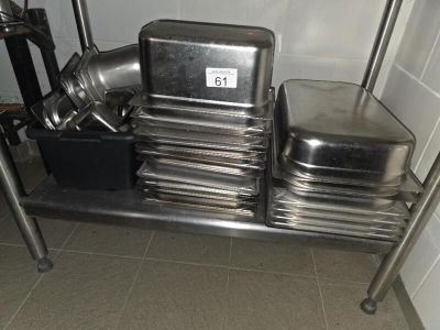several pans and pans are stacked on a metal shelf in a kitchen