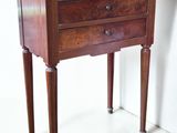 a small wooden table with three drawers on it