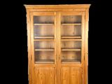 une photo d'une bibliothèque en bois avec des portes vitrées et des étagères
