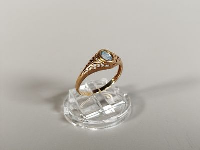 an image of a gold ring with a blue topaz stone