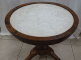 a small table with a marble top on a tiled floor