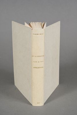 an open book sitting on top of a table next to a gray wall