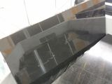 a black counter top in the middle of a kitchen