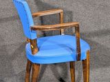 a blue chair with a wooden arm rest on a gray background