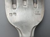 a close up of a silver fork with numbers on it