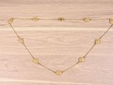 a gold necklace with coins on a wooden surface