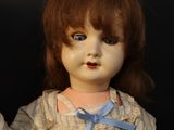 two dolls sitting next to each other on a table