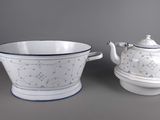 two white and blue dishes and a teapot sitting on a table