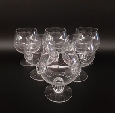 six clear wine glasses sitting on top of each other on a black surface