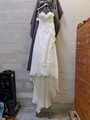 a wedding dress hanging on a clothes rack in a room