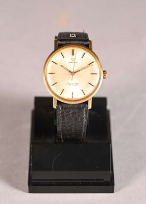 a close up of a watch on a stand on a white surface