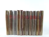 six books are lined up in a row on a white surface
