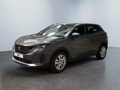 Une voiture grise est garée dans une pièce aux murs blancs.