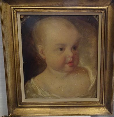 tableau représentant un bébé dans un cadre doré accroché à un mur blanc