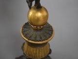 a statue of a man on top of a golden ball