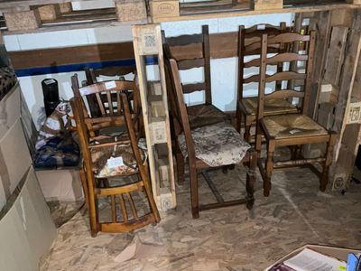 plusieurs chaises en bois et un réfrigérateur dans une pièce au sol carrelé
