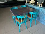a table with four chairs and a bench in a restaurant