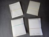 four pieces of paper with writing on them sitting on top of a table