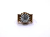 a close up of a gold ring with a white diamond