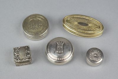some silver metal buttons and a silver ring on a white surface