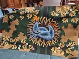 a blue couch with a green and yellow blanket on top of it