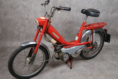 un vélo rouge avec une selle noire sur fond gris