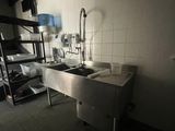 a kitchen with a sink and a ladder in the corner