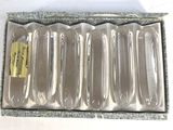 six spoons in a silver box with a yellow tag
