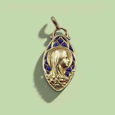 une image représentant un pendentif en or orné du portrait d'une femme dans un bateau