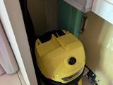 un aspirateur jaune posé dans un coin de la pièce