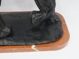 a statue of a bird sitting on top of a wooden base