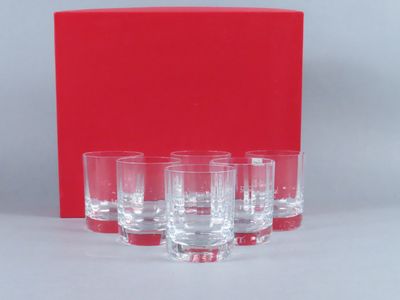 six verres posés sur une table, avec une boîte rouge en arrière-plan