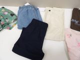 several pairs of baby clothes are laid out on a table