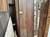 Plusieurs morceaux de bois sont empilés devant un bâtiment