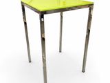 table en verre jaune avec des pieds en métal sur fond blanc