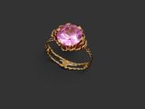 a gold ring with a pink stone on a black background