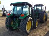 two tractors that are parked next to each other in a field