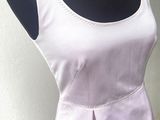une robe blanche sur un mannequin posé sur un pied de mannequin