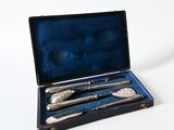 a silverware set in a black case on a white surface