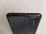 the back of a black cell phone with a broken screen