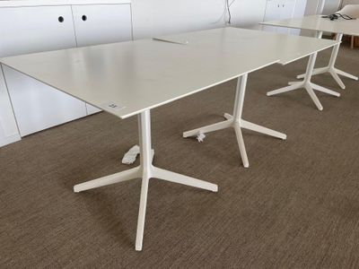 a white table with three chairs and a laptop on it