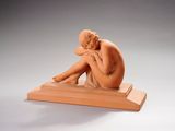 statue d'une femme assise sur une estrade en bois, les mains posées sur les genoux
