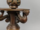 a bronze candle holder with a candle on it