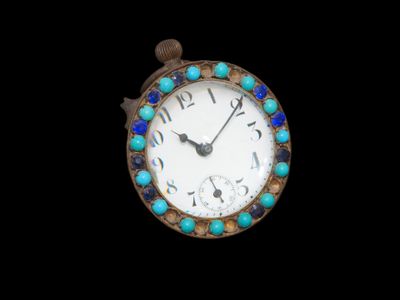un gros plan d'une petite horloge ornée de perles bleues et vertes