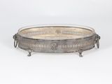 an antique silver plate with handles and handles on a stand