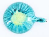 a blue and green turtle shaped bowl on a white surface