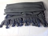 a black scarf with tassels on top of it