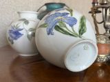 trois vases posés sur une table à côté d'un lustre